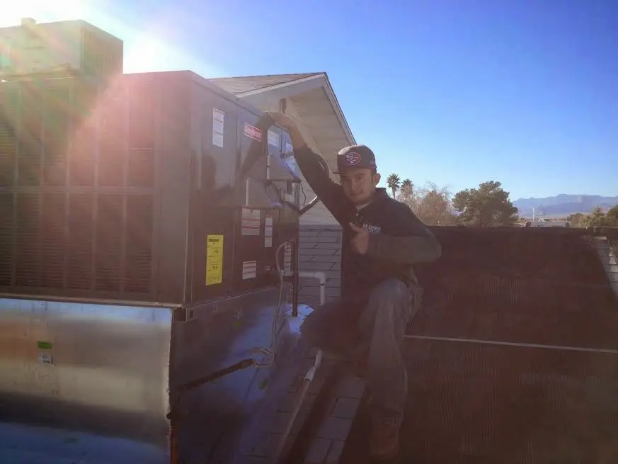 HVAC technician performing AC Tune-Up on a rooftop unit in Donaldsonville
